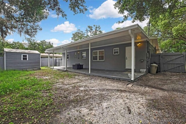 657 NE 11th St, Crystal River, FL 34428 - back of property featuring a patio area, a fenced backyard, and a gate