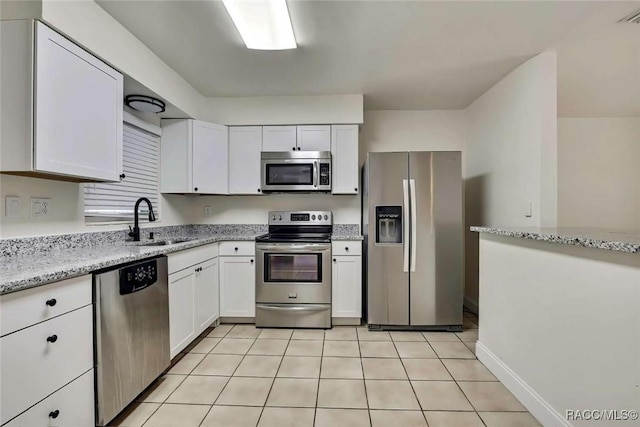 657 NE 11th St, Crystal River, FL 34428 - kitchen featuring stainless steel appliances, a sink, white cabinetry, and light stone counters