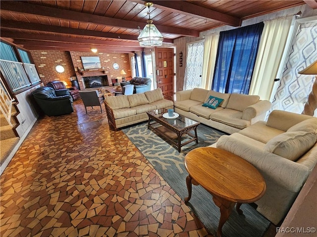 living room with brick wall, wood ceiling, beam ceiling, a notable chandelier, and a fireplace