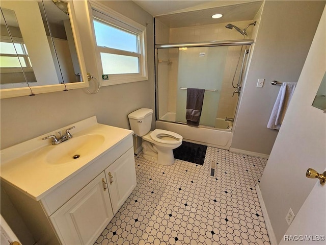 full bathroom featuring vanity, enclosed tub / shower combo, and toilet