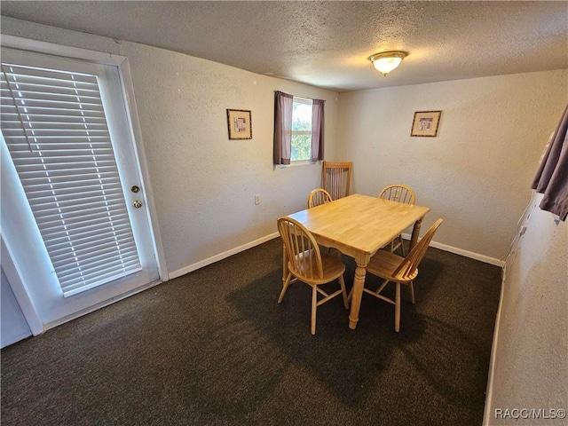 dining room with a textured ceiling and dark carpet