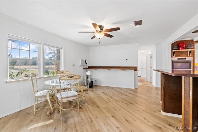 dining room with ornamental molding, ceiling fan, and light hardwood / wood-style floors