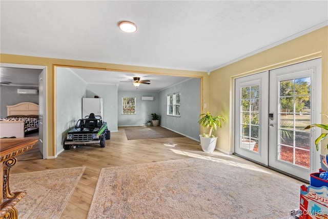 interior space featuring crown molding, a healthy amount of sunlight, light hardwood / wood-style floors, and french doors