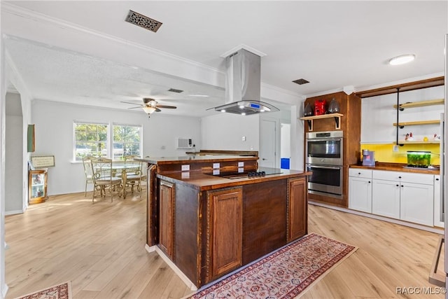 kitchen featuring a center island, island range hood, white cabinets, stainless steel double oven, and light wood-type flooring