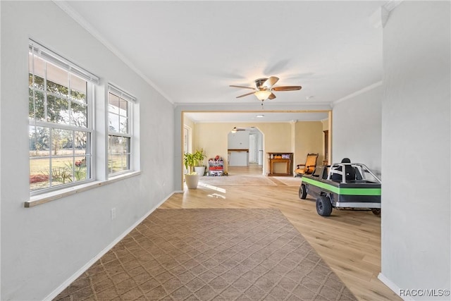 rec room with crown molding, hardwood / wood-style floors, and ceiling fan