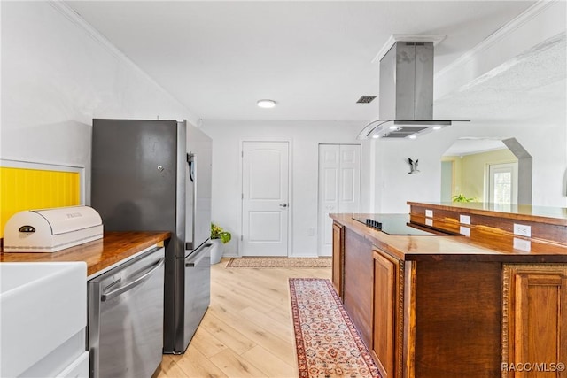 kitchen with sink, crown molding, light hardwood / wood-style flooring, stainless steel appliances, and island exhaust hood