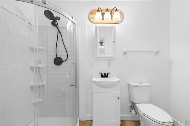 bathroom with vanity, toilet, an enclosed shower, and wood-type flooring