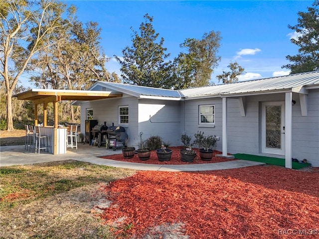 view of home's exterior with exterior bar and a patio