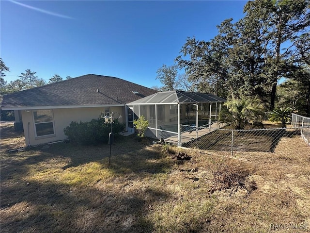 rear view of property featuring a yard, a swimming pool, and a lanai