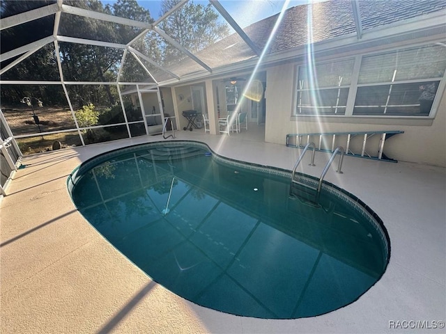 view of swimming pool with a lanai and a patio area