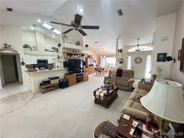 carpeted living room with ceiling fan and high vaulted ceiling