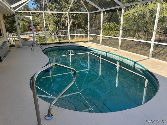 view of swimming pool featuring a patio and a lanai