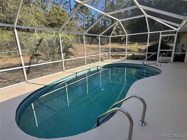 pool with a patio area and glass enclosure