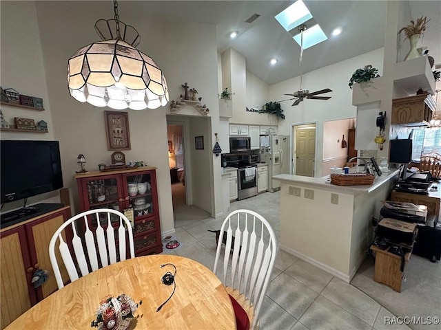 dining room featuring high vaulted ceiling, light tile patterned floors, ceiling fan, and a skylight