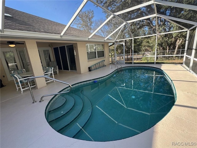 view of swimming pool featuring glass enclosure and a patio area