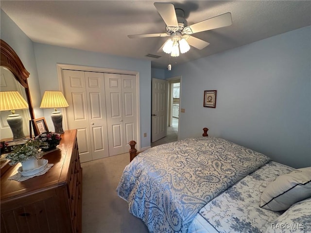 bedroom with ceiling fan, carpet, and a closet