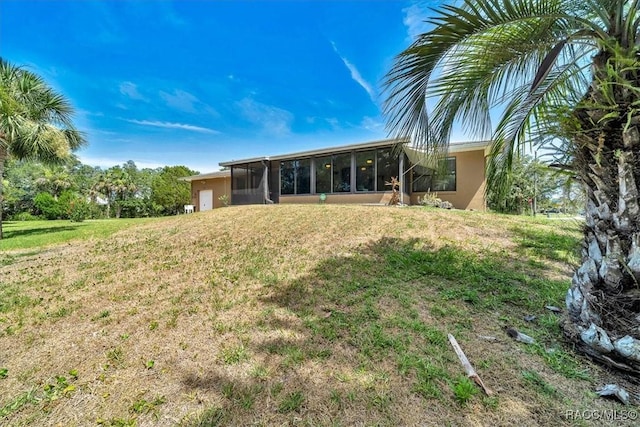 10741 W Pine Bark Ln, Crystal River, FL 34429 - back of property with a sunroom, stucco siding, and a yard
