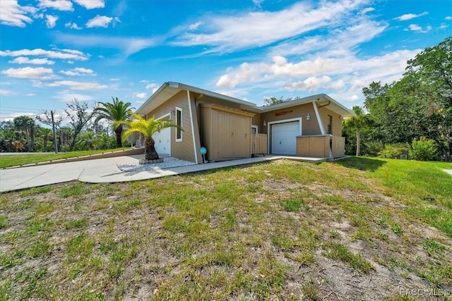 10741 W Pine Bark Ln, Crystal River, FL 34429 - view of side of property featuring a garage, driveway, and a lawn