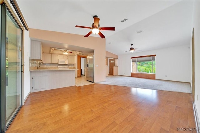 10741 W Pine Bark Ln, Crystal River, FL 34429 - unfurnished living room with light wood-style flooring, a ceiling fan, and vaulted ceiling