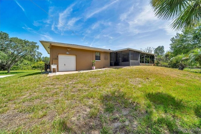 10741 W Pine Bark Ln, Crystal River, FL 34429 - rear view of property with a sunroom, an attached garage, stucco siding, and a lawn