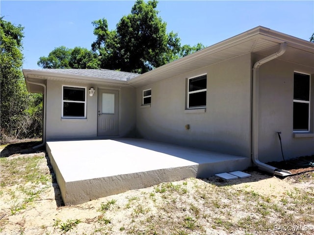 back of property with a patio area and stucco siding