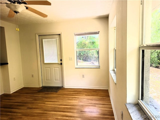 interior space with baseboards, ceiling fan, and wood finished floors