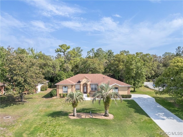 mediterranean / spanish-style home with stucco siding, driveway, and a front lawn