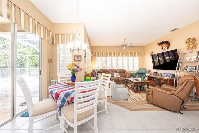 living area with visible vents, ceiling fan with notable chandelier, and light tile patterned floors