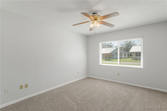 carpeted spare room with ceiling fan, a textured ceiling, and baseboards