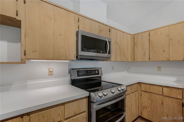 kitchen with stainless steel appliances, light countertops, light brown cabinets, and a textured ceiling