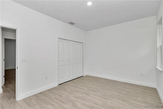 7858 N Merrimac Way, Citrus Springs, FL 34434 - unfurnished bedroom featuring light wood-style flooring, baseboards, and a closet