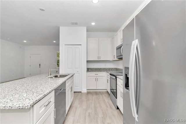 7858 N Merrimac Way, Citrus Springs, FL 34434 - kitchen featuring appliances with stainless steel finishes, a sink, a center island with sink, recessed lighting, and light stone counters