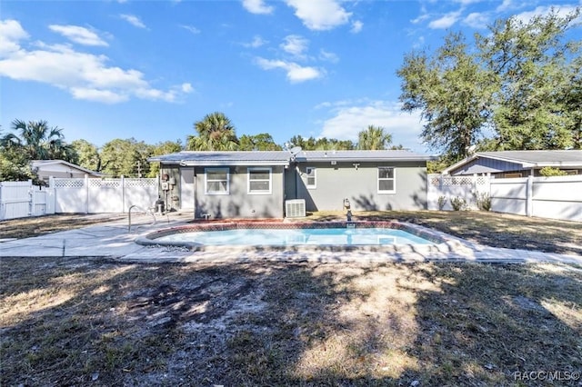 back of house with a patio area, a fenced in pool, and central AC