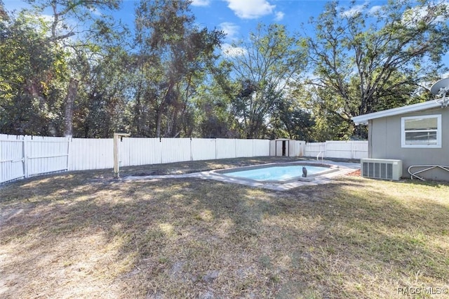 view of swimming pool featuring central AC and a yard