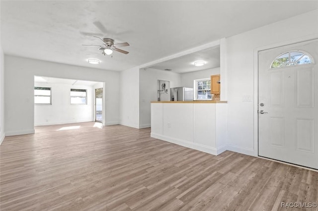 foyer entrance featuring ceiling fan and light wood-type flooring