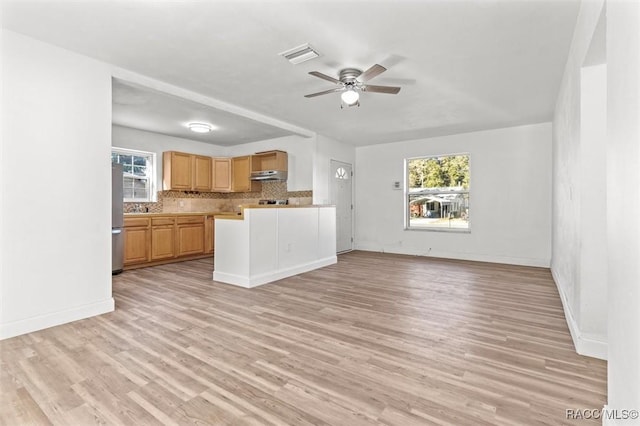 kitchen with decorative backsplash, a healthy amount of sunlight, light wood-type flooring, and light brown cabinetry