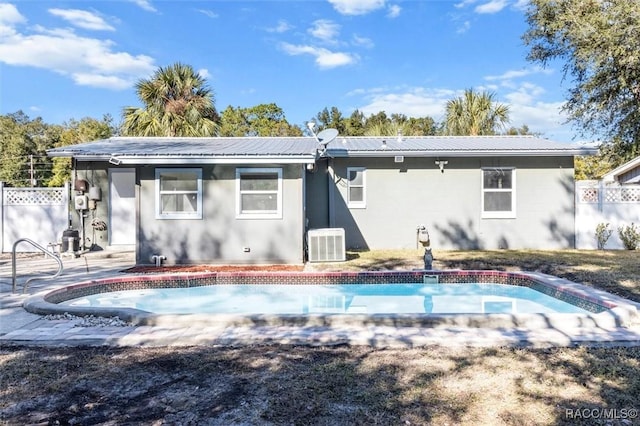 back of property with a patio, a fenced in pool, and cooling unit