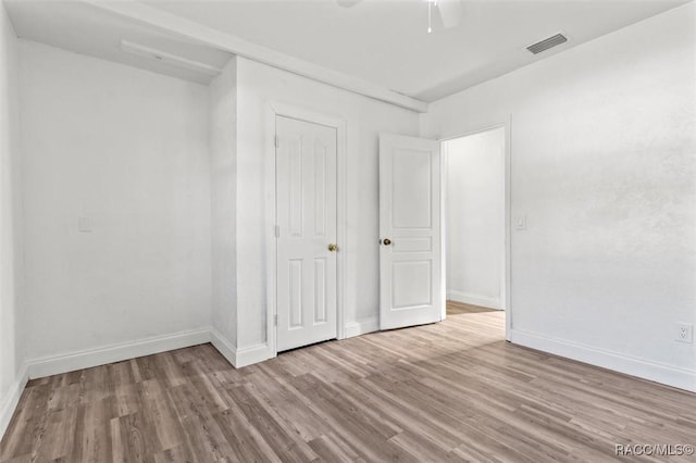 unfurnished bedroom featuring ceiling fan, light wood-type flooring, and a closet