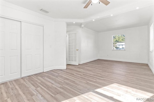 unfurnished bedroom featuring ceiling fan, light wood-type flooring, and a closet