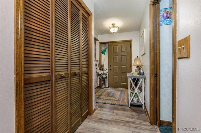 entryway featuring baseboards and light wood finished floors