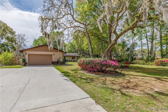 view of front of house with a garage, driveway, a front lawn, and fence