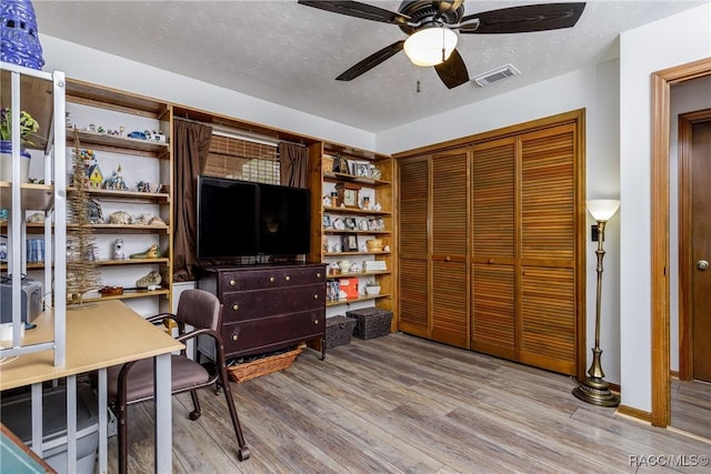 office area featuring visible vents, ceiling fan, a textured ceiling, wood finished floors, and baseboards