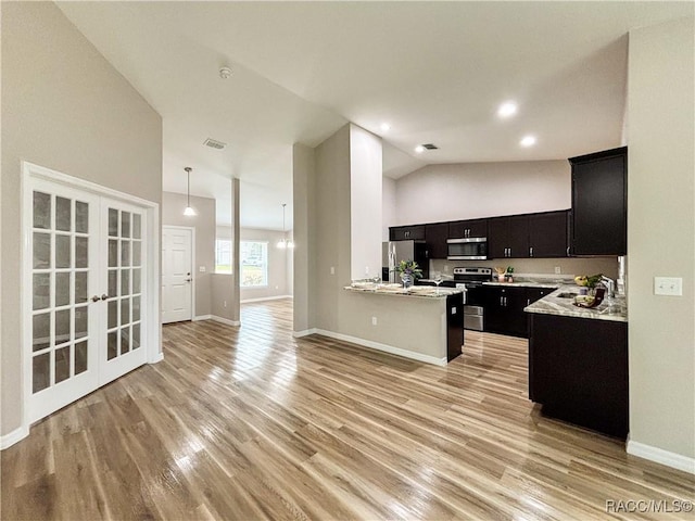 6431 SW 145th Ln, Ocala, FL 34473 - kitchen with stainless steel appliances, dark cabinetry, open floor plan, light countertops, and high vaulted ceiling