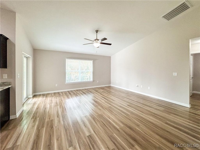 6431 SW 145th Ln, Ocala, FL 34473 - unfurnished living room with a ceiling fan, light wood finished floors, and vaulted ceiling
