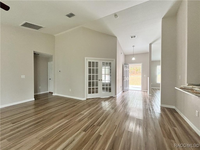 6431 SW 145th Ln, Ocala, FL 34473 - unfurnished living room featuring french doors, wood finished floors, and vaulted ceiling