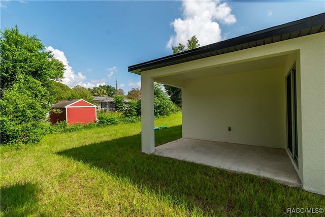 view of yard with a storage shed and a patio