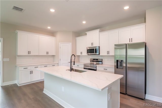 kitchen with white cabinetry, sink, stainless steel appliances, dark hardwood / wood-style floors, and a center island with sink