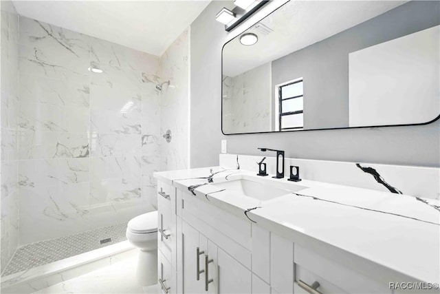full bathroom featuring marble finish floor, vanity, toilet, and tiled shower