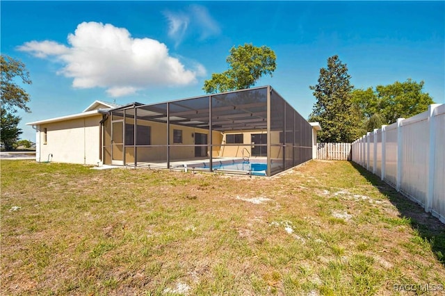 back of house featuring a lawn, a fenced backyard, a fenced in pool, and glass enclosure