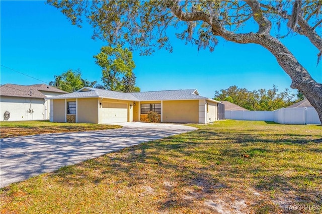 view of front of property featuring aphalt driveway, fence, a front lawn, stucco siding, and an attached garage
